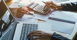 A person engaged in accounting service using a calculator, ensuring operational and financial data accuracy