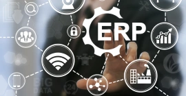 An individual working on a laptop featuring ERP software solutions catered to all businesses for efficient management