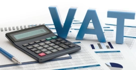 A finance document, a pen, and a calculator to perform VAT-value-added tax computations for business services